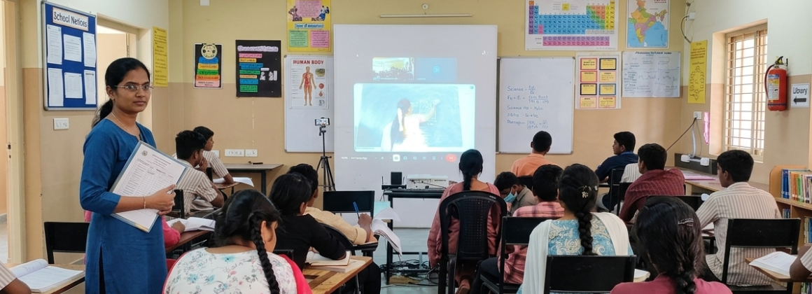 Teacher explaining a lesson using a smart board in class